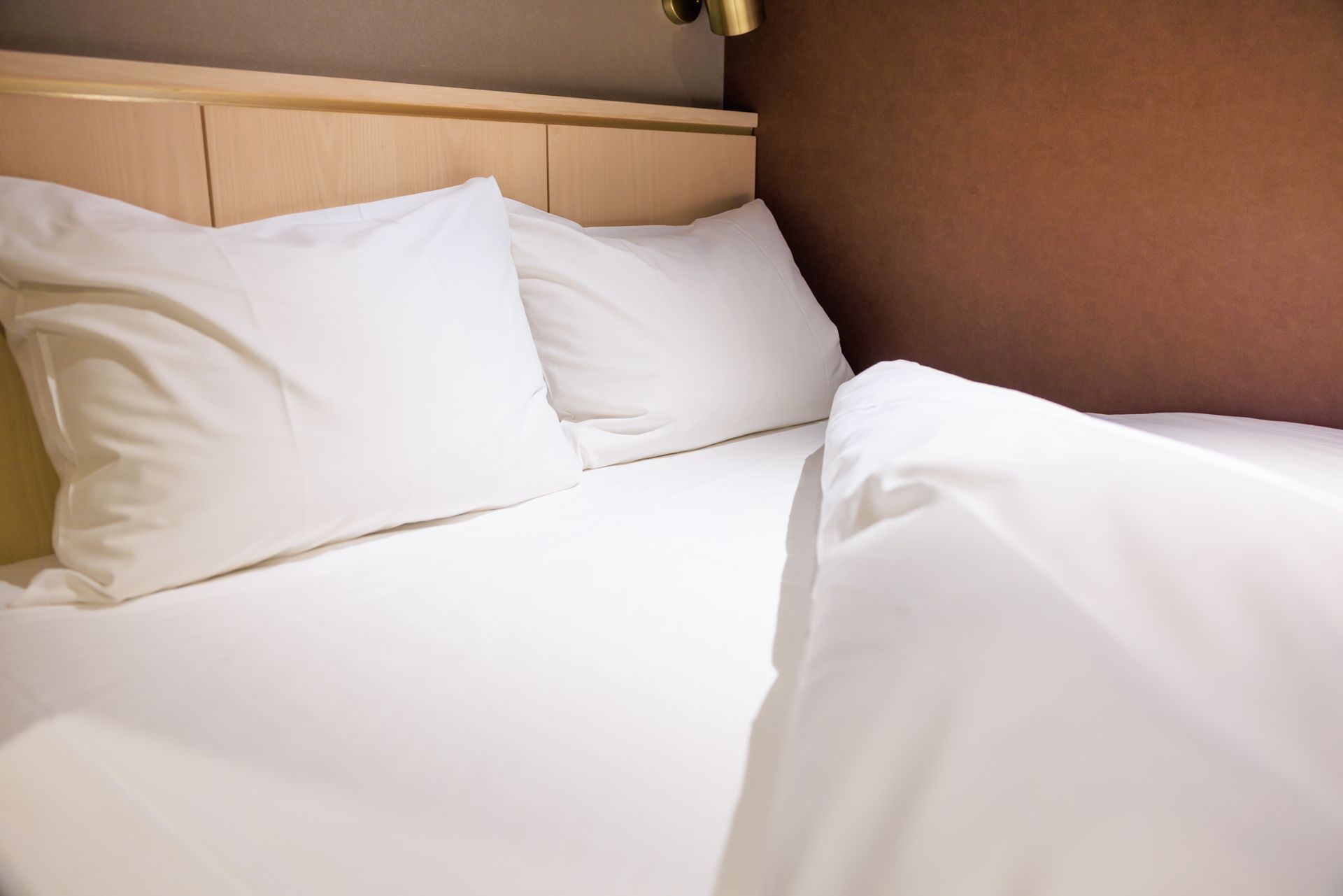 Linge de lit blanc dans une chambre d'hôtel.