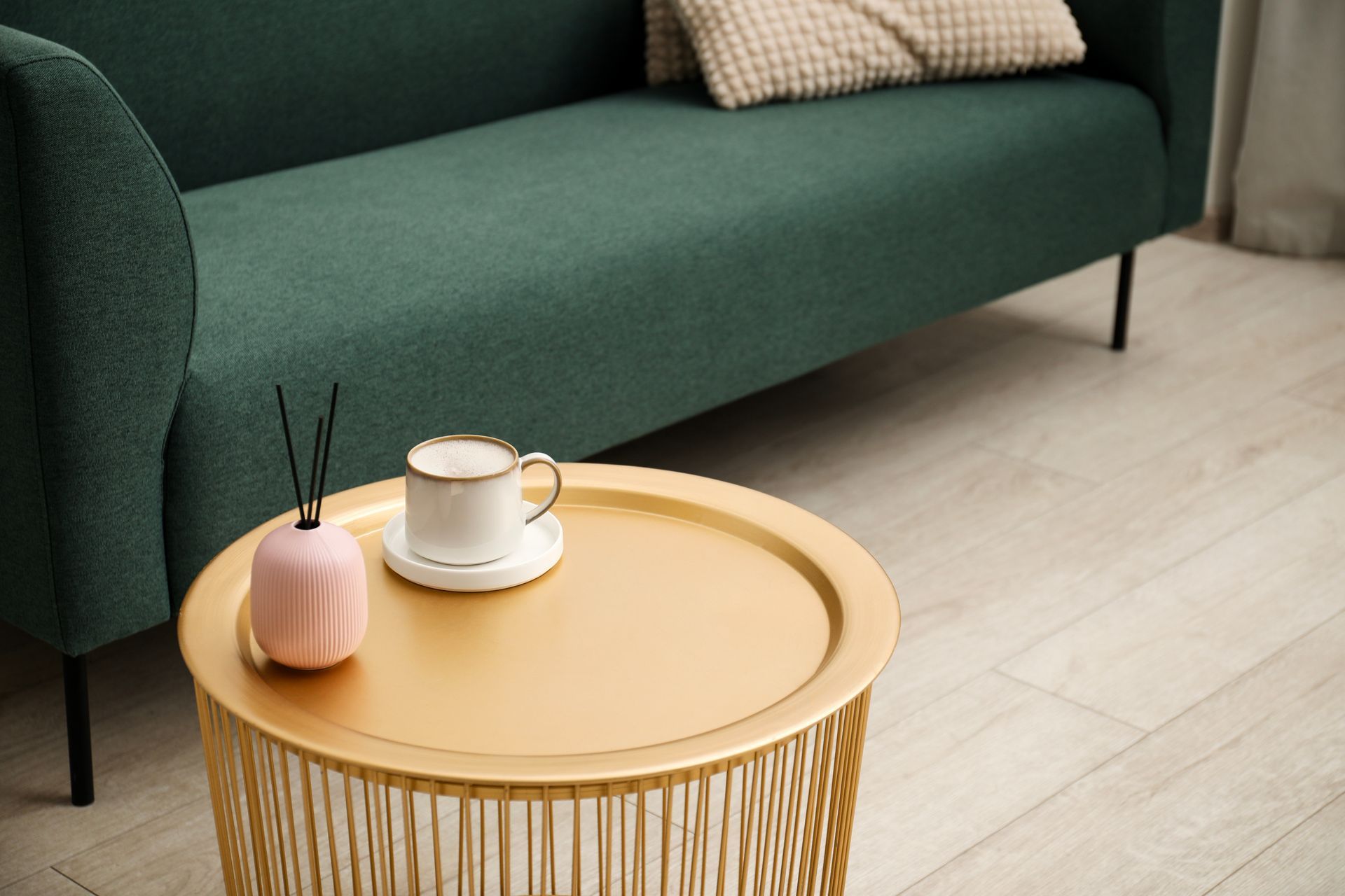 Focus sur un canapé vert sapin et une table basse en bois.
