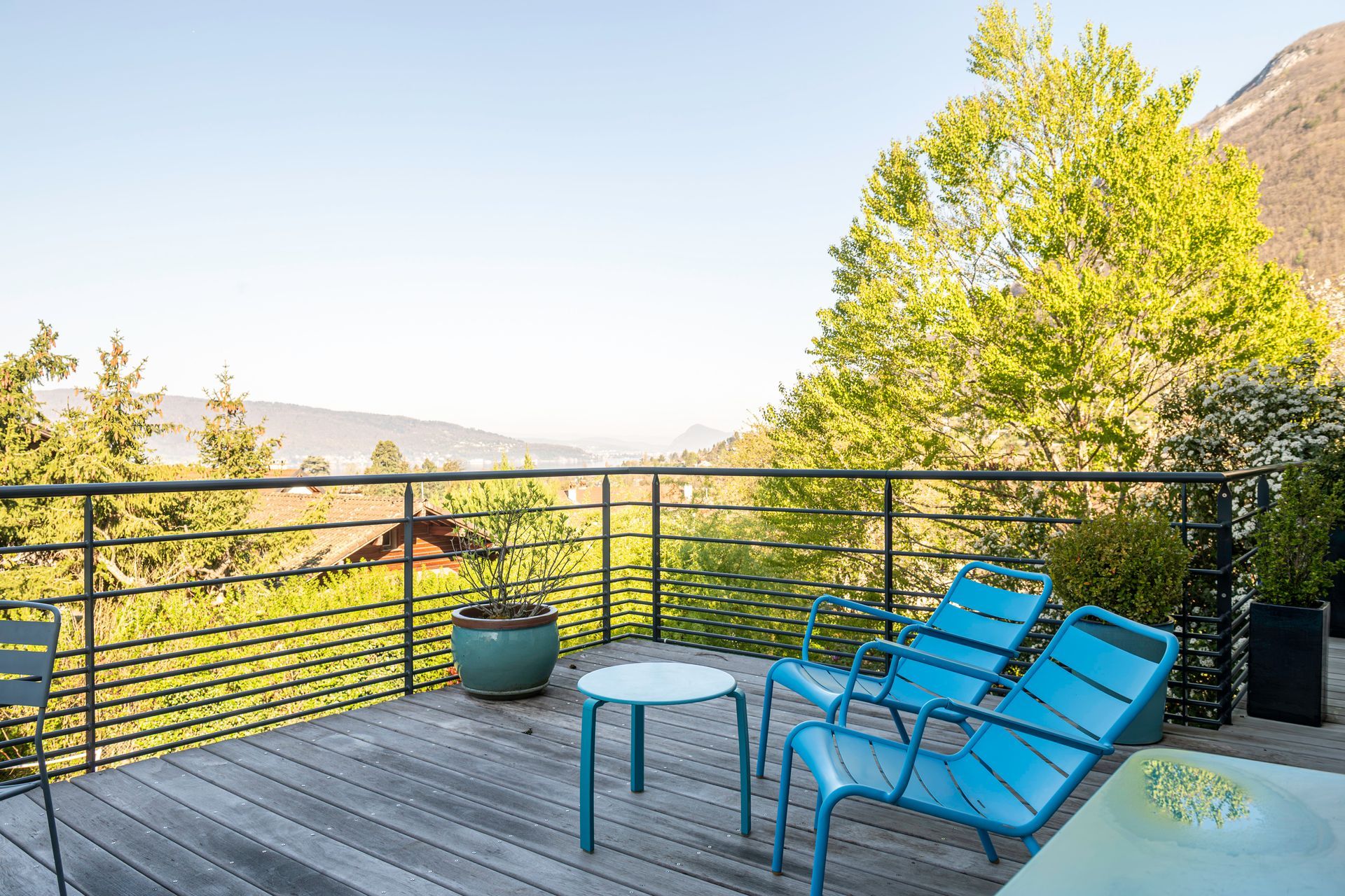 Grande terrasse avec des chaises bleues