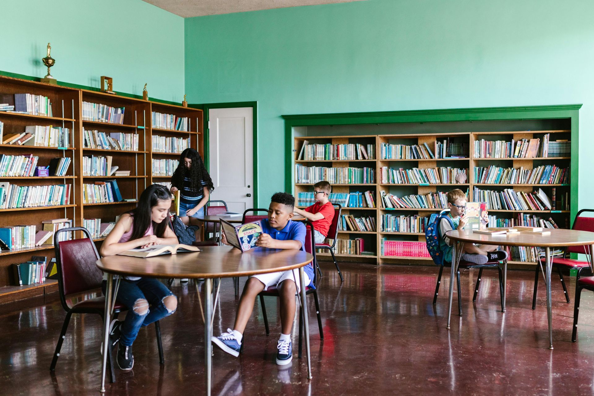 Bibliothèque scolaire avec élèves assis à des tables