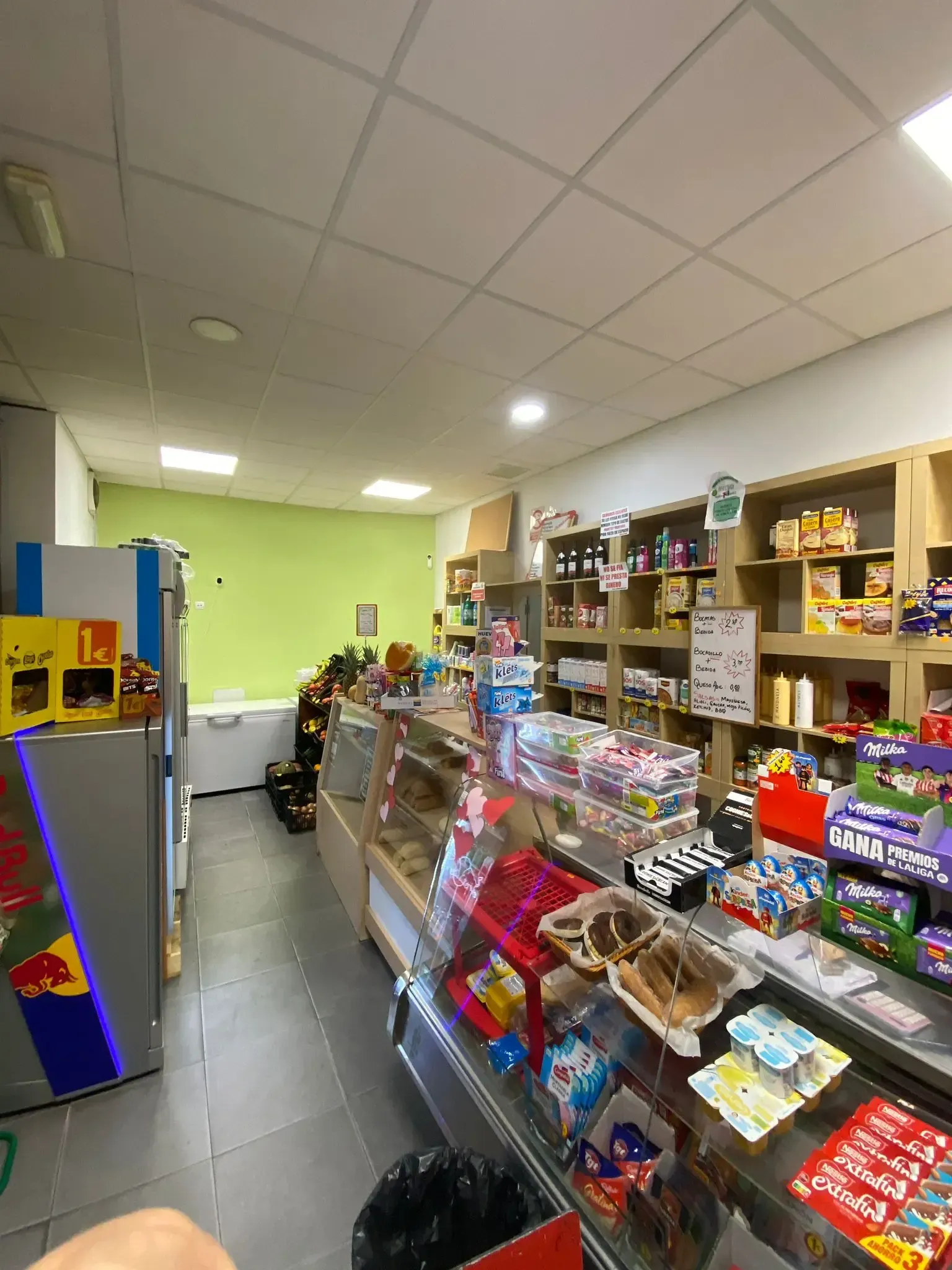 Un estrecho pasillo de dulces en una tienda de conveniencia, repleto de coloridos bocadillos y bolsas de papas fritas.