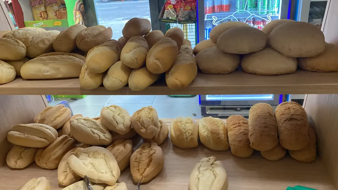 Estantes con panes y bollos surtidos en el mostrador de una panadería.