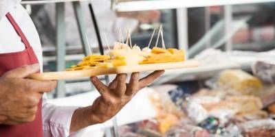 Una persona sostiene una bandeja de comida en sus manos.
