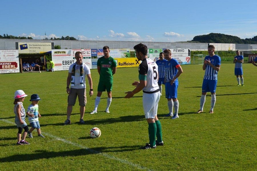 Eine Gruppe von Leuten spielt auf einem Feld Fußball.