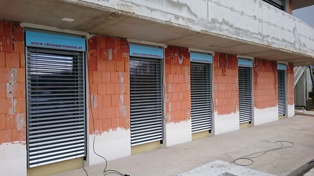 Ein im Bau befindliches Gebäude mit vielen Fenstern und Jalousien