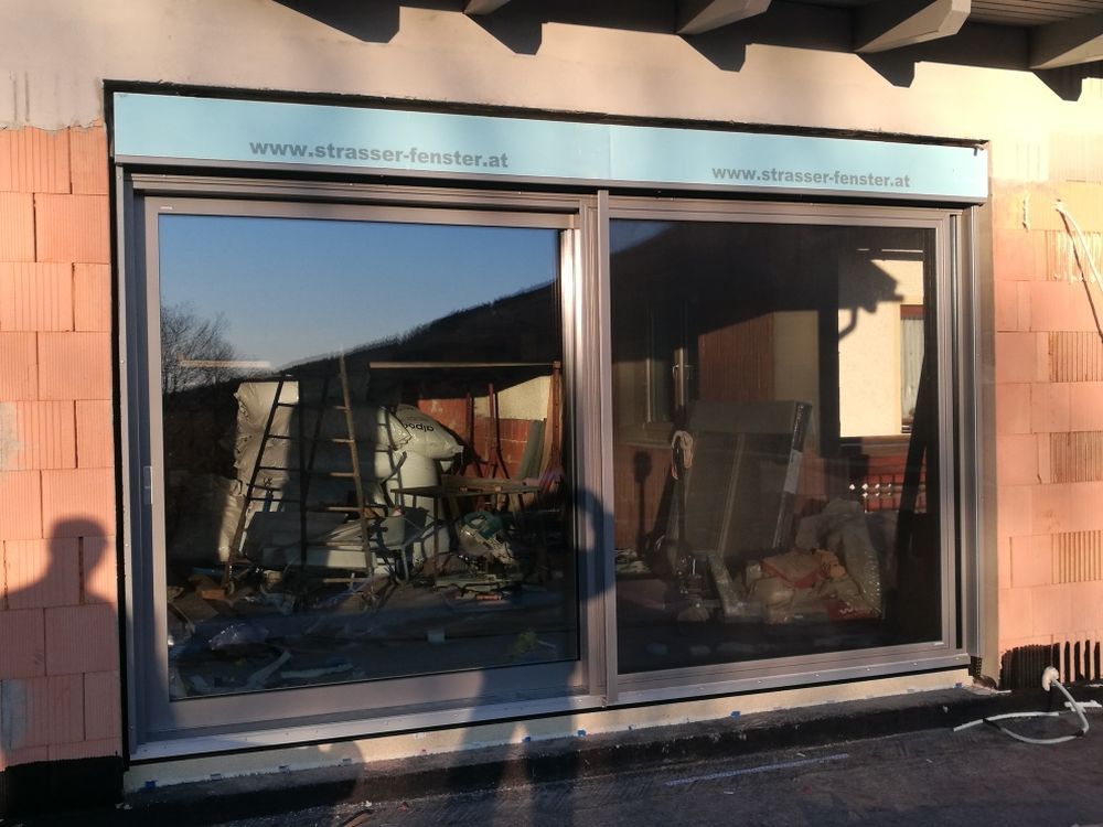 An der Seite eines Gebäudes wird eine Glasschiebetür installiert