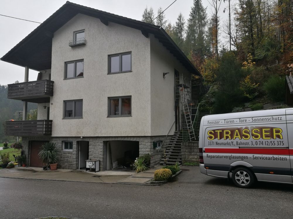 Ein Strasser-Van steht vor einem Haus