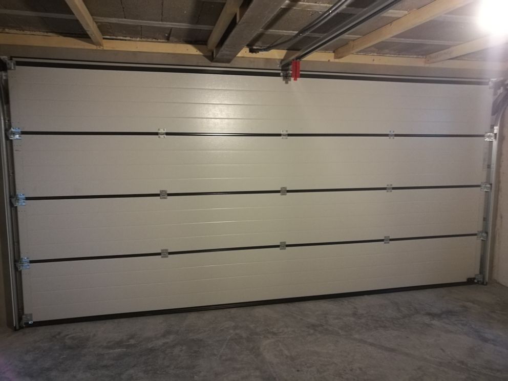 In einer Garage ist ein weißes Garagentor geöffnet.