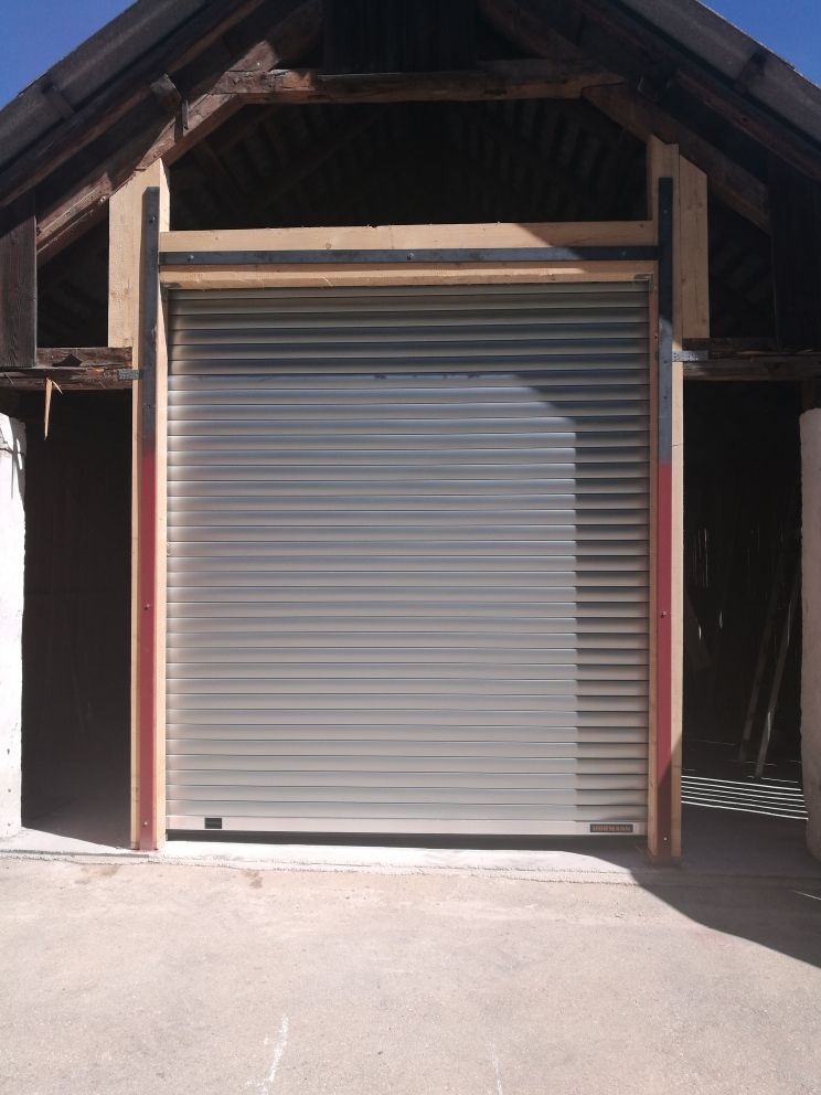 Ein Garagentor mit Holzdach ist geöffnet