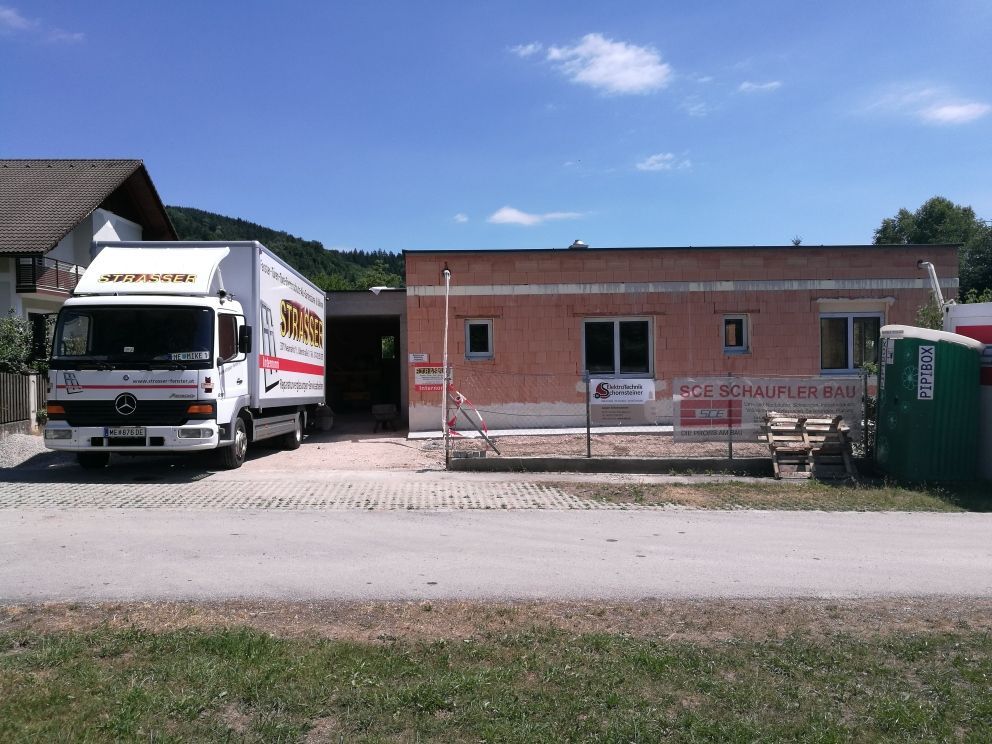 Zwei Lastwagen stehen vor einem Backsteingebäude