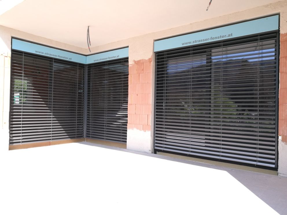 Ein Gebäude mit vielen Fenstern mit Jalousien