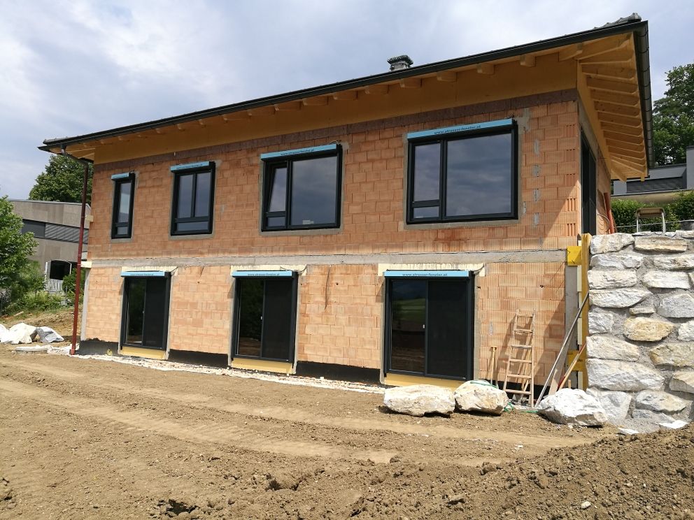 Es entsteht ein Backsteinhaus mit vielen Fenstern.