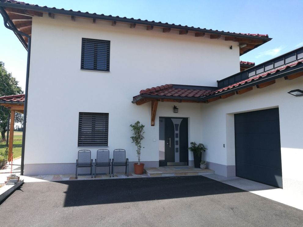 Ein weißes Haus mit einem schwarzen Garagentor