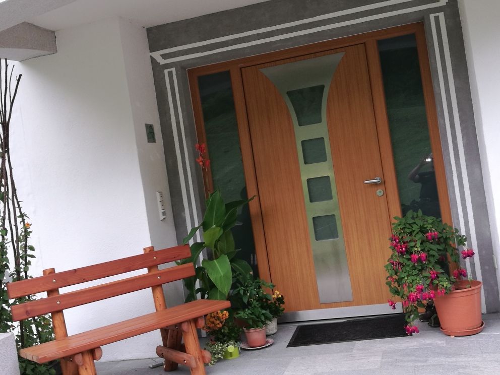 Eine Holzbank steht vor einer Holztür