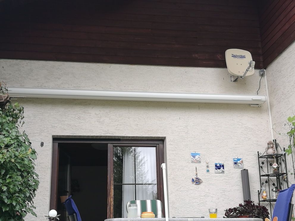 Eine Satellitenschüssel ist an der Seite eines Gebäudes montiert