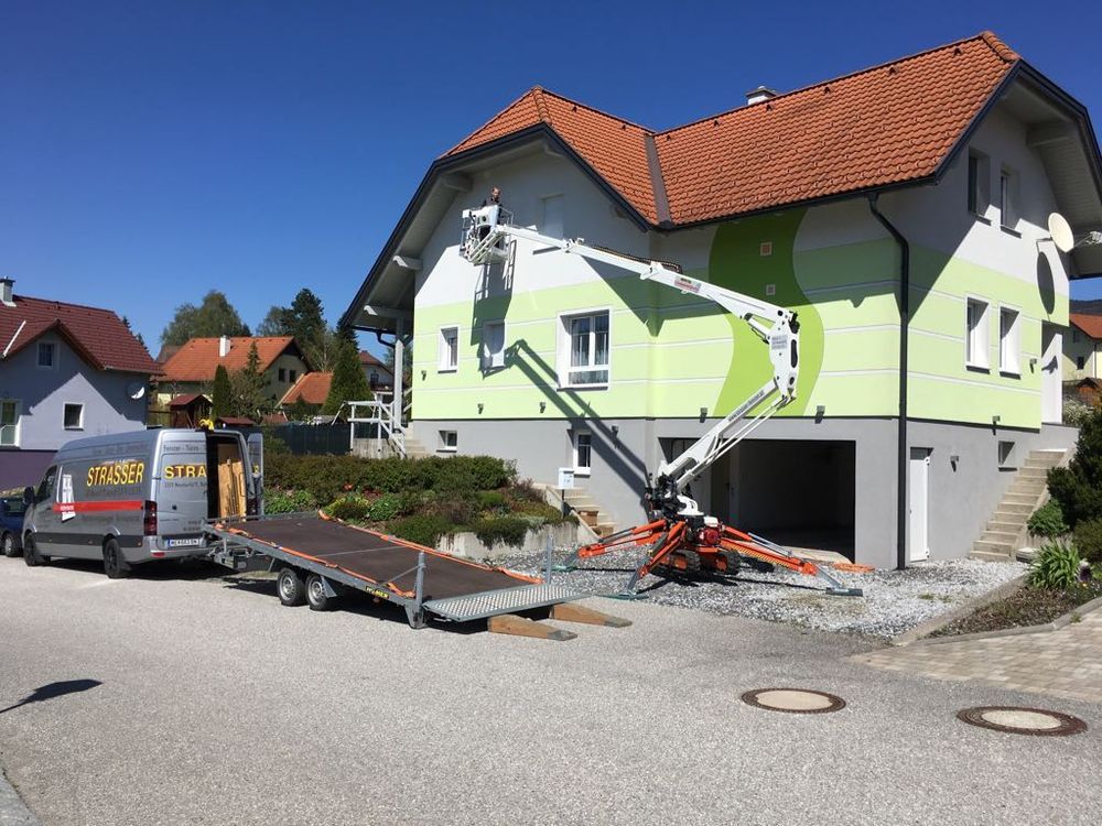 Ein Haus wird gestrichen, davor steht ein Aufzug