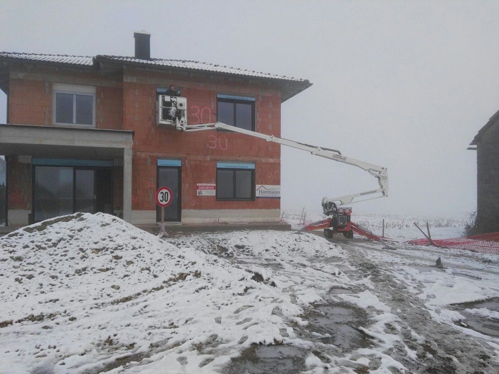 Im Schnee wird ein großes Backsteinhaus gebaut