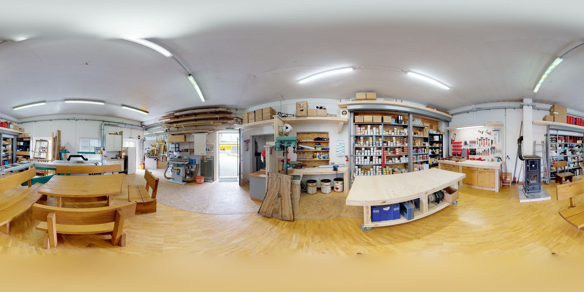Eine 360-Grad-Ansicht einer Holzwerkstatt voller Holztische und -bänke.