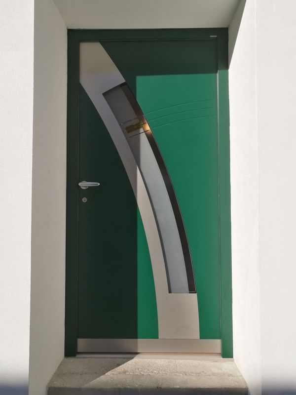 Eine grüne Tür mit einem geschwungenen Muster darauf