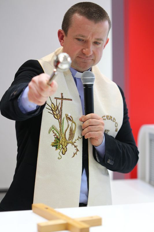 Ein Mann trägt einen weißen Schal mit einem Kreuz darauf