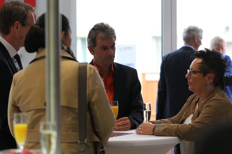 Eine Gruppe von Menschen sitzt um einen Tisch herum und unterhält sich