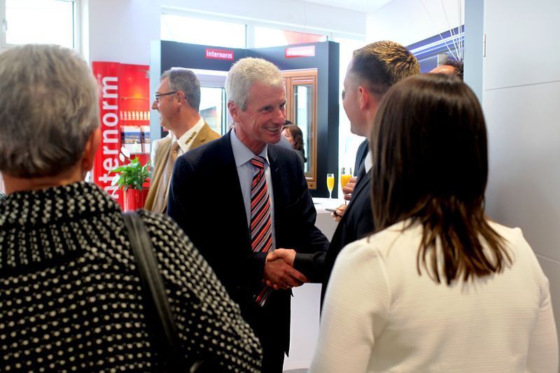 Ein Mann in Anzug und Krawatte schüttelt einer Frau die Hand