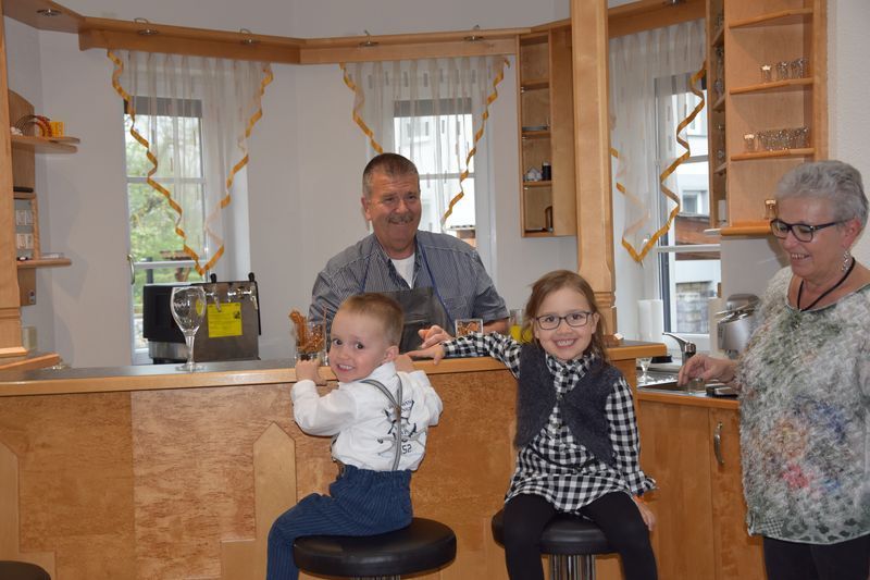 Ein Mann und zwei Kinder sitzen in einer Bar.