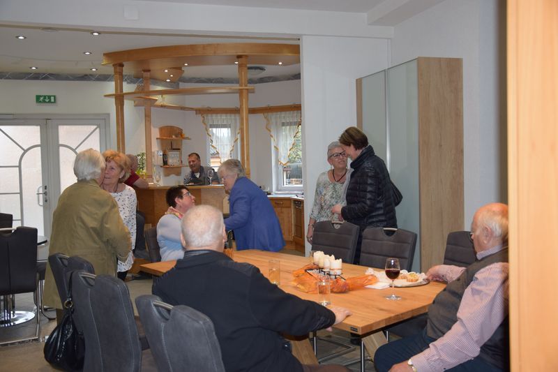 Eine Gruppe von Leuten sitzt in einem Raum um einen Tisch herum.