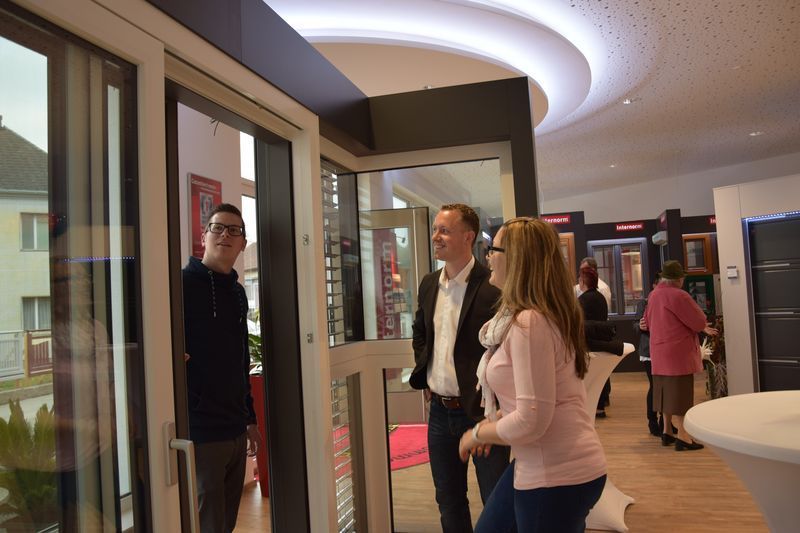Eine Gruppe von Leuten steht in einem Raum und schaut aus einem Fenster.