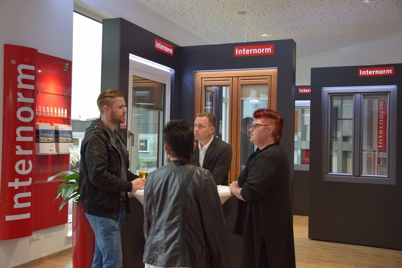 Eine Gruppe von Menschen steht vor einem Schild mit der Aufschrift „Internorm“