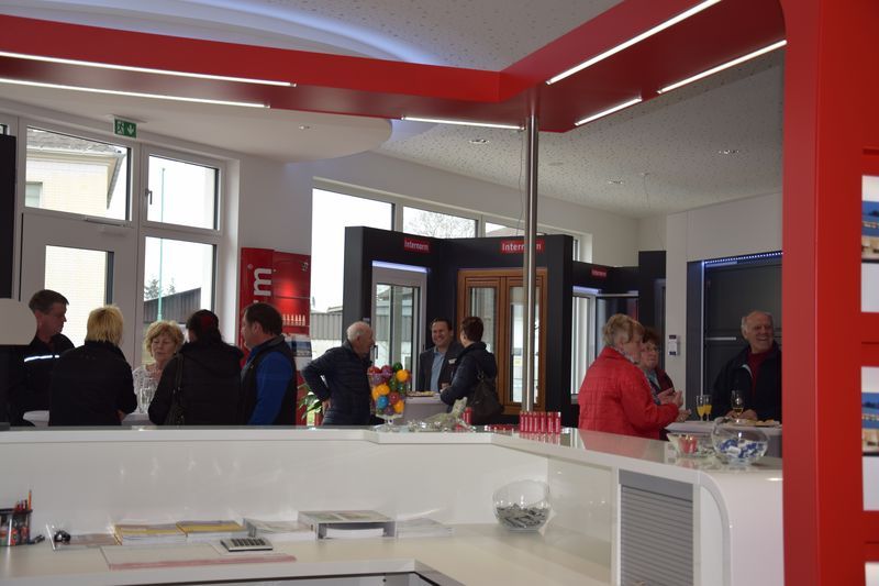 Eine Gruppe von Menschen steht in einem Restaurant um eine Theke herum.