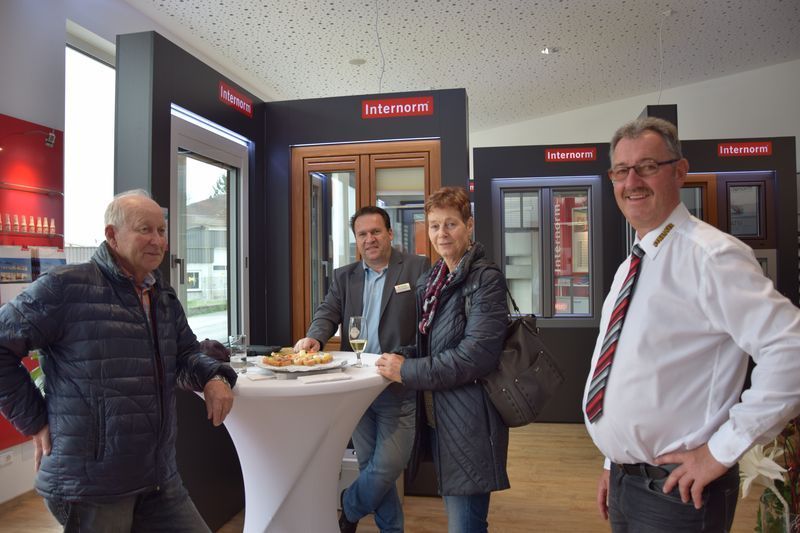 Eine Gruppe von Leuten steht in einem Raum um einen Tisch herum.