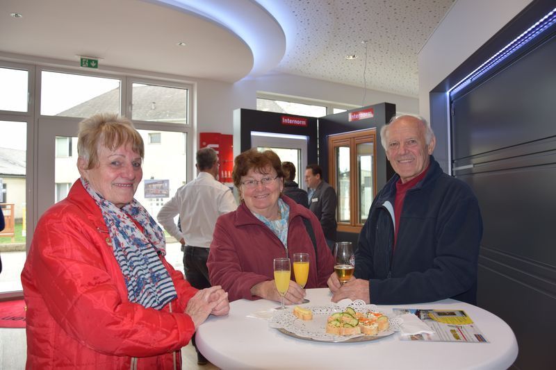 Eine Gruppe Leute sitzt an einem Tisch und trinkt Champagner.