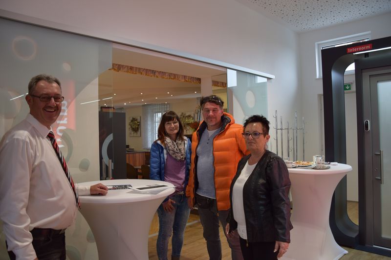 Eine Gruppe von Leuten steht in einem Raum um einen Tisch herum.