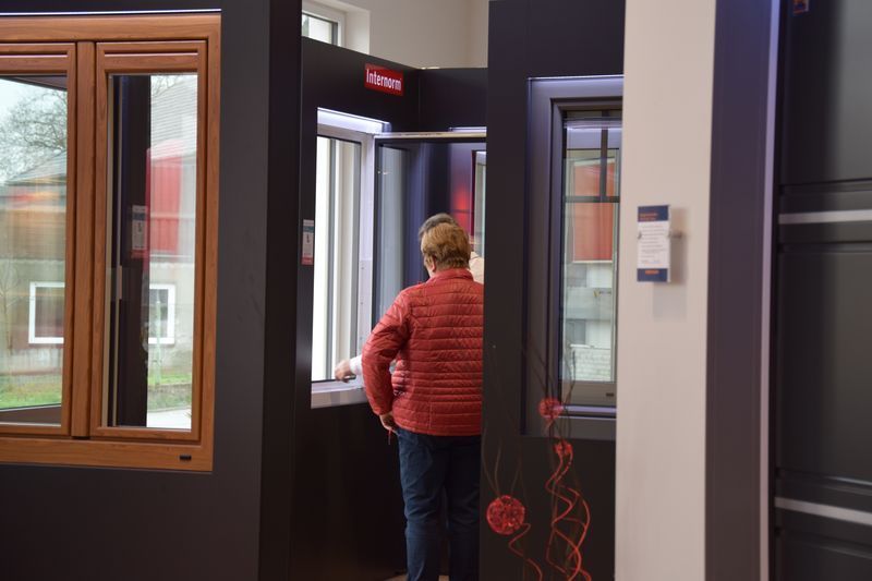 Eine Frau steht in einem Zimmer und schaut aus einem Fenster.