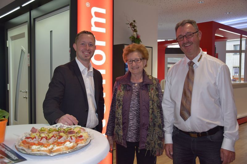 Drei Personen stehen vor einem Schild mit der Aufschrift „Formular“