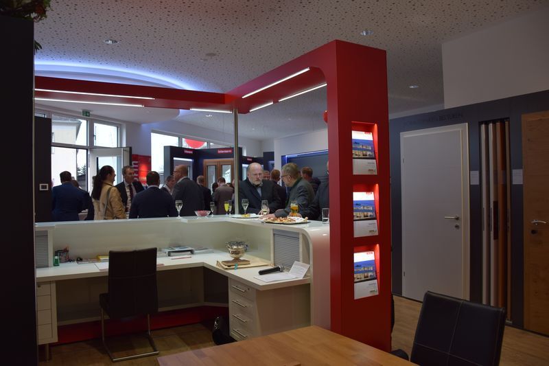 Eine Gruppe von Leuten steht in einem Raum um einen Tisch herum.