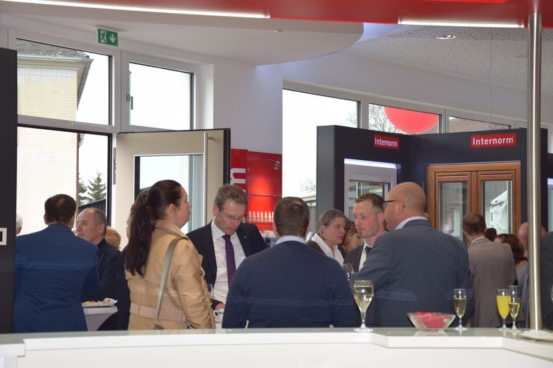 Eine Gruppe von Leuten steht in einem Raum und unterhält sich.