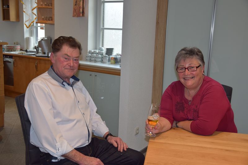 Ein Mann und eine Frau sitzen mit einem Glas Wein an einem Tisch.
