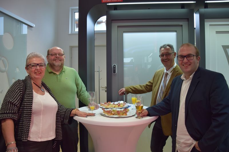 Eine Gruppe von Leuten steht um einen Tisch herum, auf dem Essen steht.