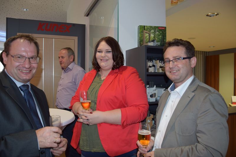 Eine Gruppe von Leuten steht nebeneinander und hält Getränke in den Händen.