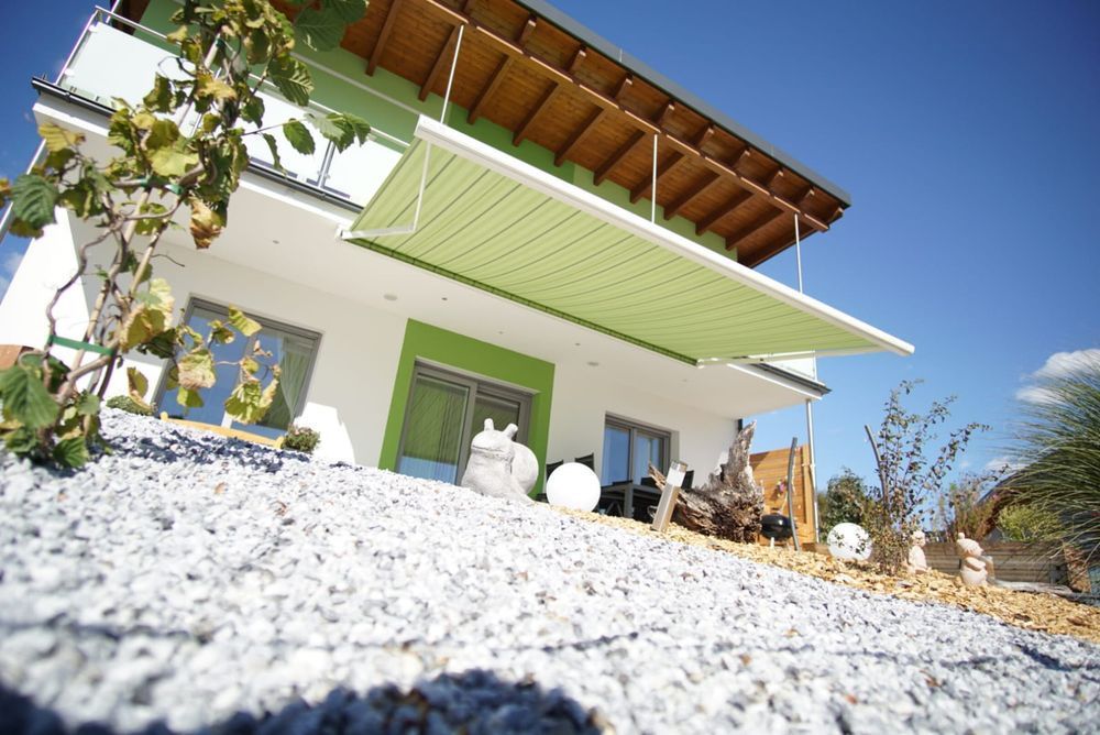 Ein Haus mit einer grünen Markise an der Seite