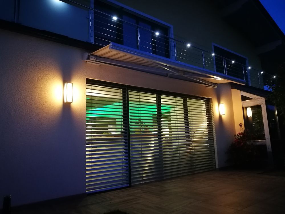 Ein Haus mit Balkon und Jalousien an den Fenstern in der Nacht