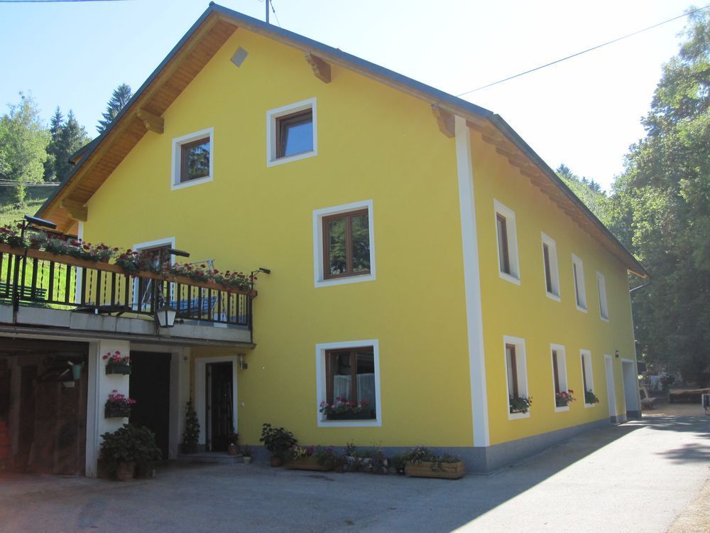 Ein gelbes Haus mit einem Balkon und vielen Fenstern