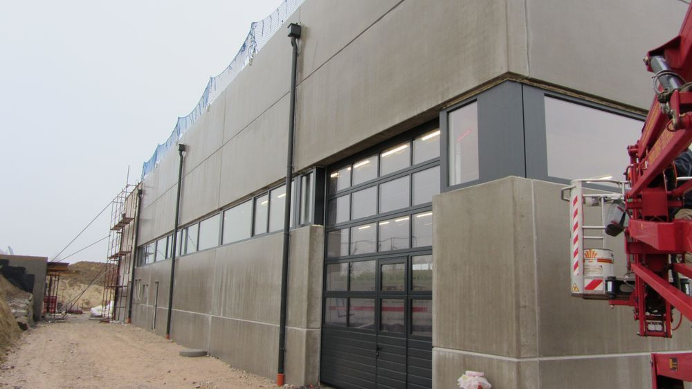 Ein im Bau befindliches Gebäude mit einem roten Kran davor.