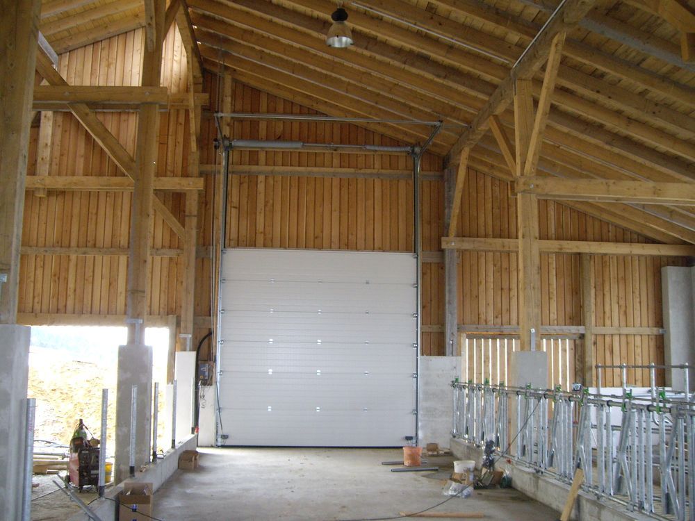 Das Innere einer Scheune mit einer großen weißen Tür.