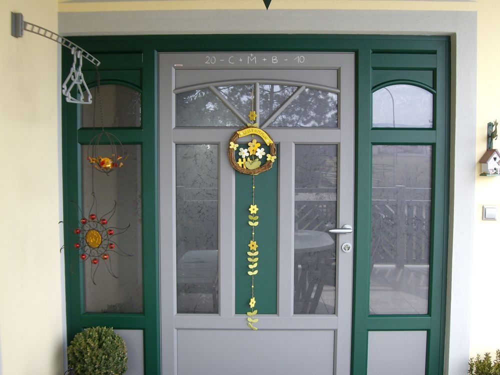Eine grüne Tür mit einer Sonnen- und Monddekoration darauf