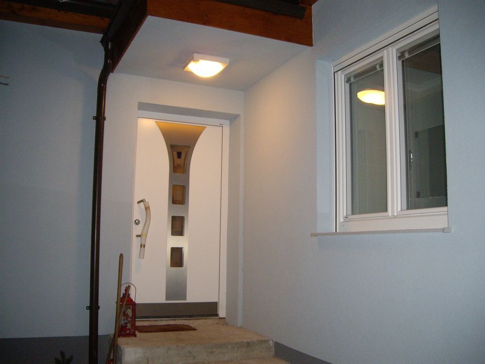 Eine weiße Tür mit einem Fenster daneben