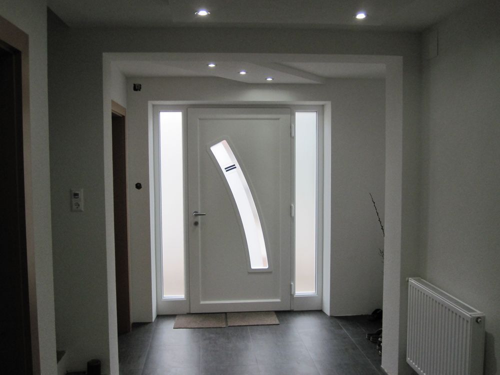 Ein Flur mit einer weißen Tür und zwei Fenstern
