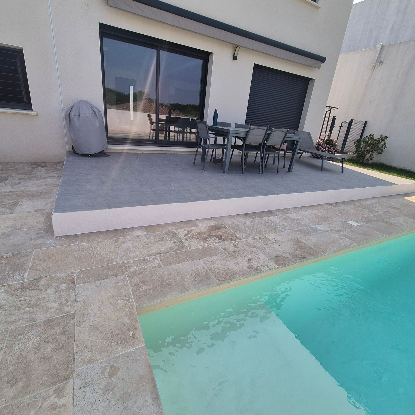 Terrasse en carrelage au bord d'une piscine